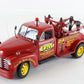 A red vintage tow truck model with yellow wheels, featuring 'DM Road Service' graphics and a red light on top, photographed on a white background.