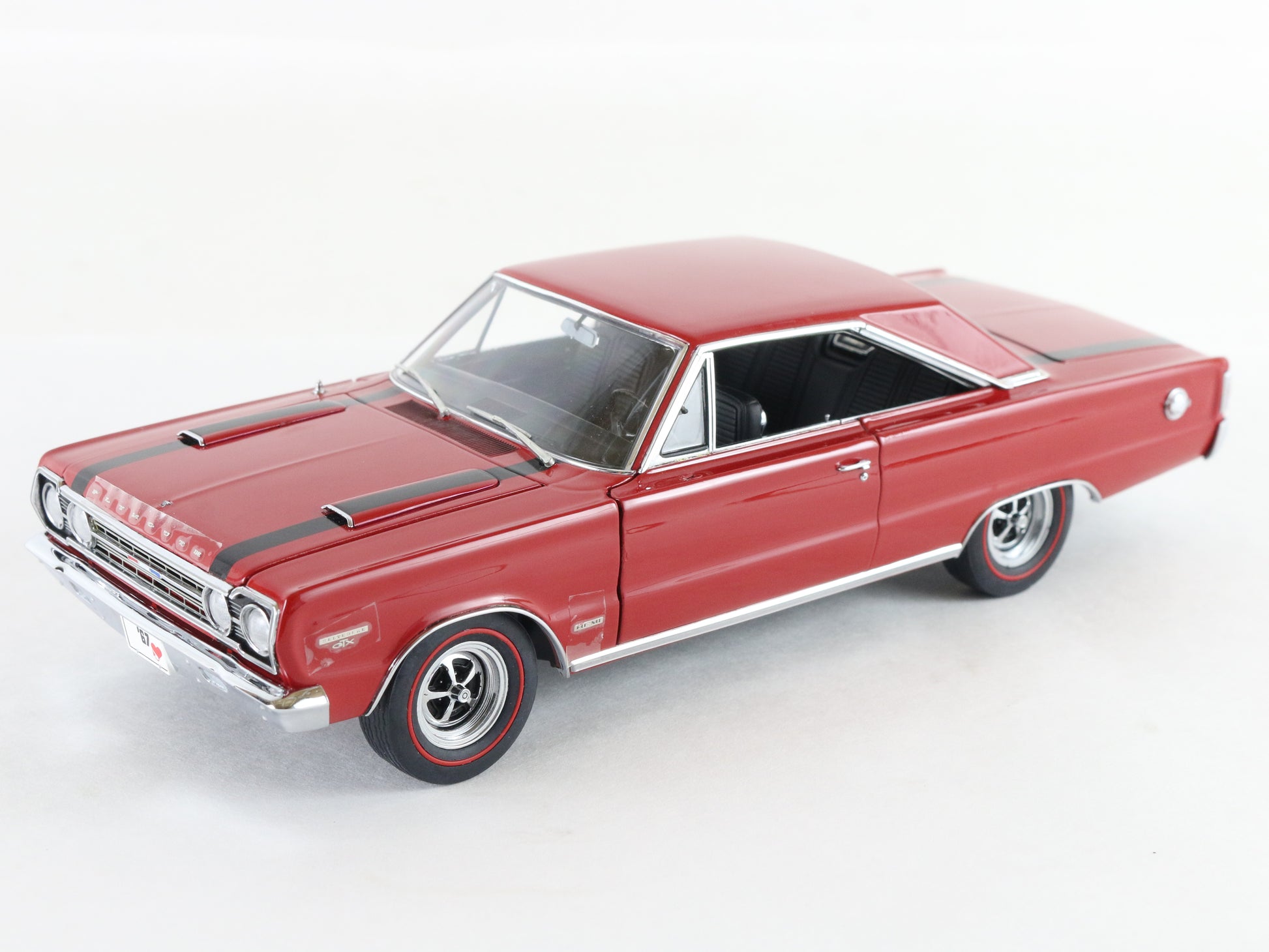 A red die-cast model car, resembling a classic American muscle car, shown from a three-quarters front angle on a clean white background.